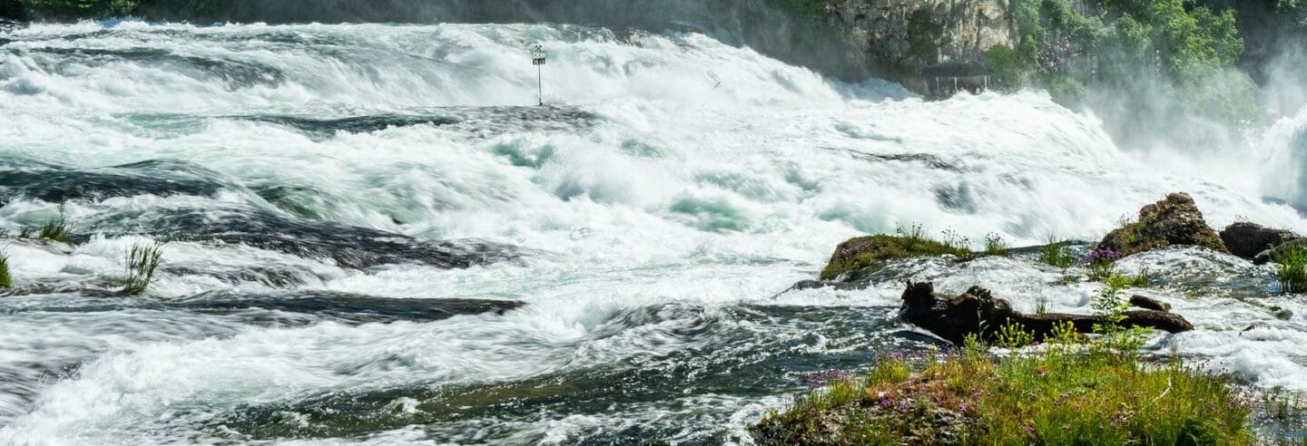 cascade of large creeks on wide river in rhine falls in switzerland